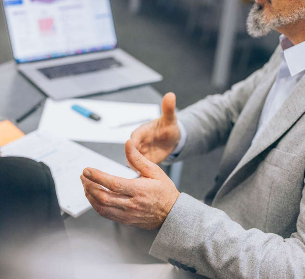 Détail des mains et bras d'un intervenant lors d'une séance consulting en entreprise