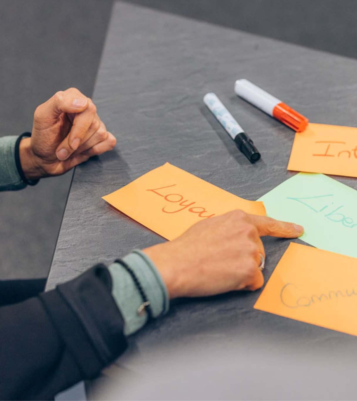 Détails de mains et de feuilles annotées lors d'une séance de travail